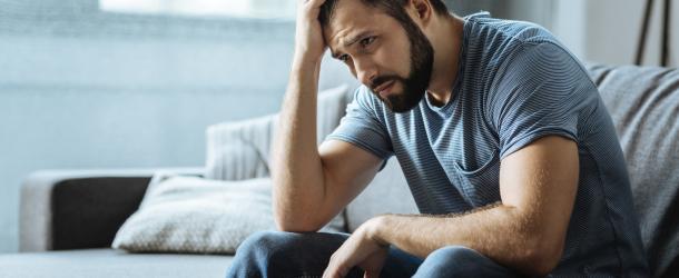 Man sitting with hand on forehead